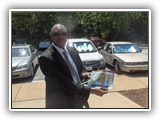 Photo of Gen Boroh showing a brochure for NAPKC.